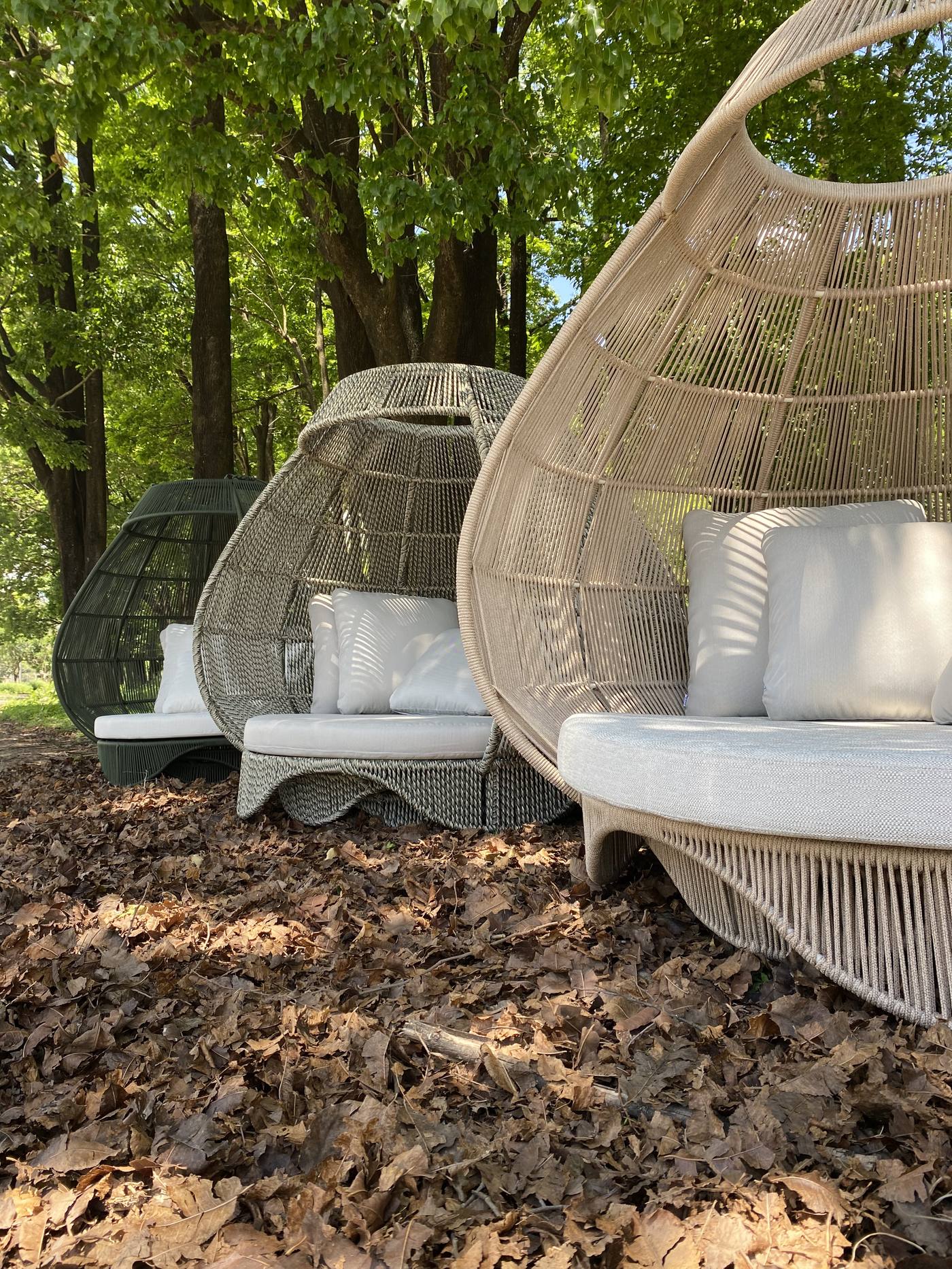 Poltronas ninho trançadas em ambiente externo arborizado